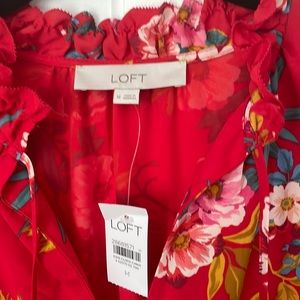 A bright floral dress. Loose fit, ruffle cap sleeves. Tie closure at the neck